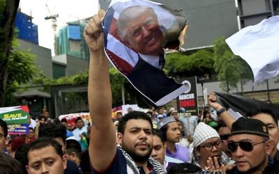 Protesters burn Donald Trump's during a protest outside the U.S. Embassy in Kuala Lumpur, Malaysia, Friday, Dec. 8, 2017. Malaysian Muslims, including members of the ruling party, hold protest outside U.S. Embassy over Washington's controversial move to recognize Jerusalem as Israel's capital. (AP Photo/Sadiq Asyraf)