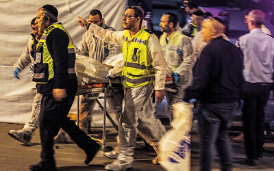 Hadera, Israel. 27th Mar, 2022. Medics transport the body of a victim into an ambulance where two people were killed by gunmen in Hadera. Credit: Ilia Yefimovich/dpa - ATTENTION: graphic content/dpa/Alamy Live News