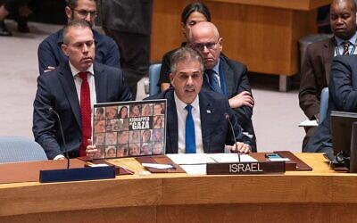 Foreign Minister of Israel Eli Cohen speaks while holding photos of kidnapped Israelis during the SC meeting on the situation in the Middle East at UN Headquarters in New York on October 24, 2023