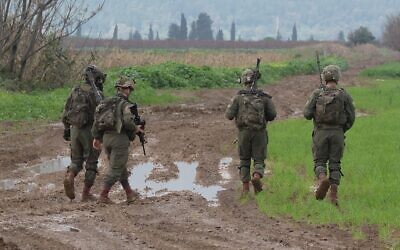 Israeli soldiers search a field after two explosive-laden drones were reportedly used by Hezbollah militants to launch an aerial assault against an Israeli air defense system site near Kibbutz Blum close to the border with Lebanon