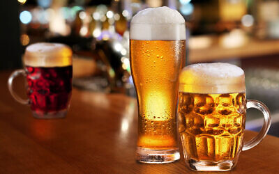 Glass of light beer on a dark pub.