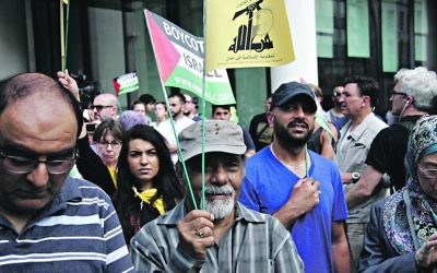 Anti-Israel demonstrators on the Al Quds Day march, holding pro-Palestine banners and flags, including that of proscribed terror group, Hezbollah.