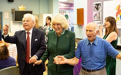 links arms with Jewish Care president Lord Levy (left) and a Brenner Centre user during a rendition of Hava Nagilah. (Credit: Sam Churchill Photography)