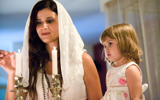 BFDJHE Mother and daughter lighting Shabbat candles.