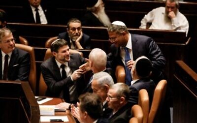 Israel's Finance Minister Bezalel Smotrich shakes hands with Israel's Minister of National Security Itamar Ben-Gvir as Israel's new right-wing government is sworn in at the Knesset, Israel's parliament in Jerusalem December 29, 2022. REUTERS/Amir Cohen/Pool/File Photo